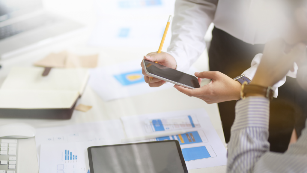 personne tenant un téléphone portable et une tablette