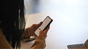 femme tenant son mobile dans les mains