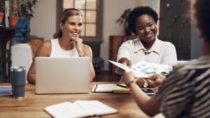 femmes souriantes devant des ordinateurs