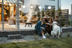 femmes et hommes caressant un chien dans un jardin