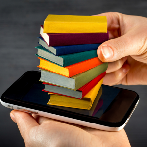 des mains tenant un mobile et des livres