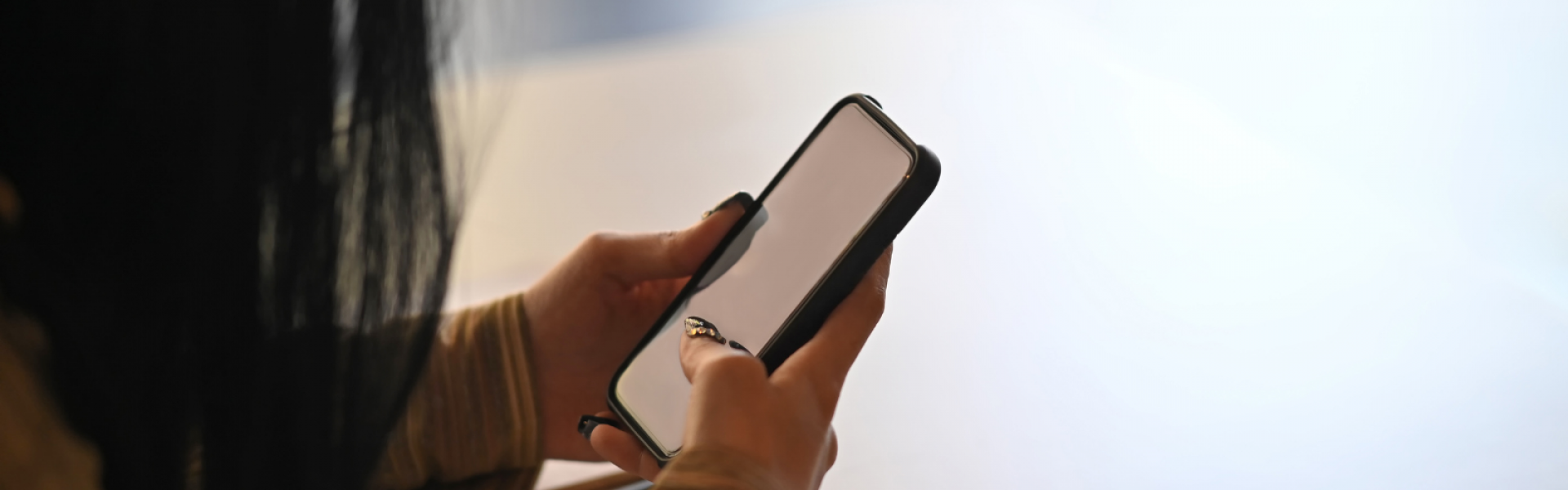 femme tenant son mobile dans les mains