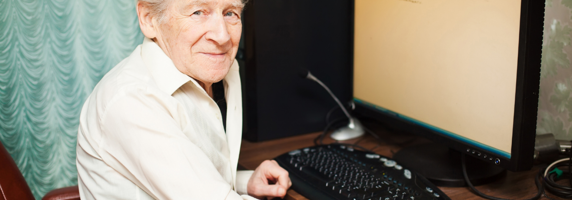 personne âgée en chemise blanche devant son ordinateur
